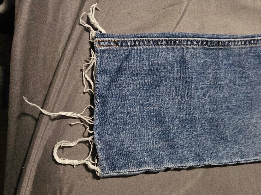 Medium wash straight leg denim jeans frayed raw hem five pocket zip fly